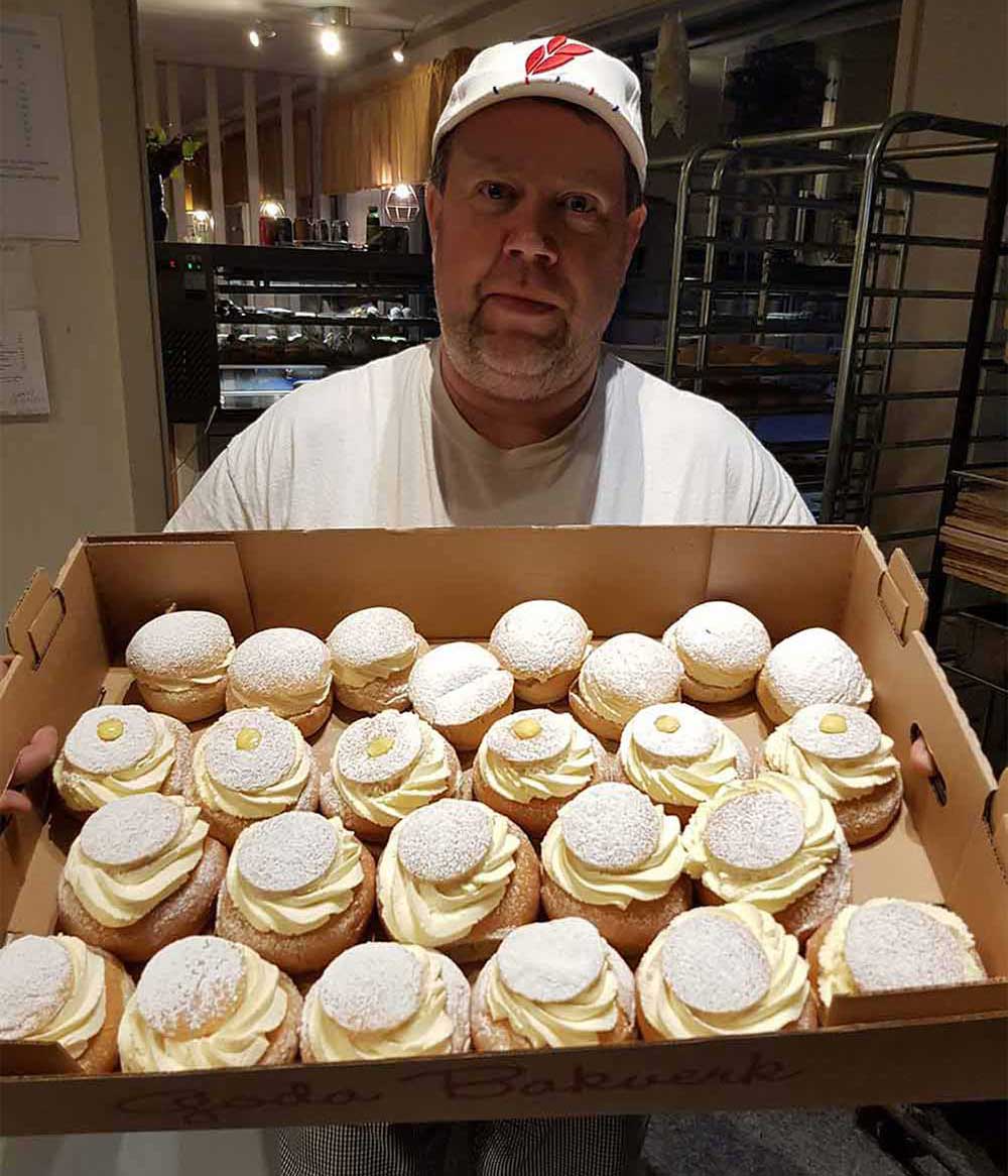 Bagare som håller i nybakta semlor